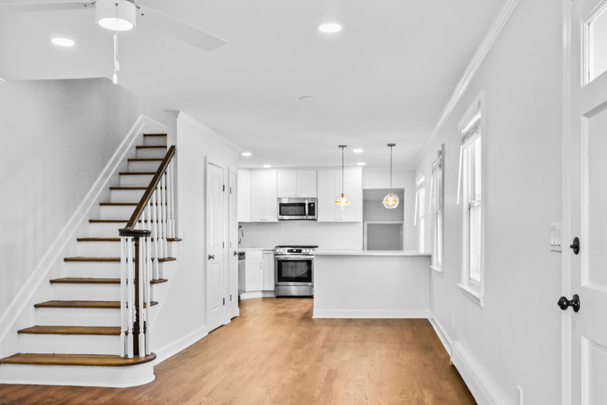 Renovated open kitchen layout with staircase to second floor